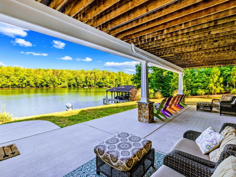 Covered Patio - Wicker sofas and cool shade make this lower patio the easy daytime gathering spot above the water.