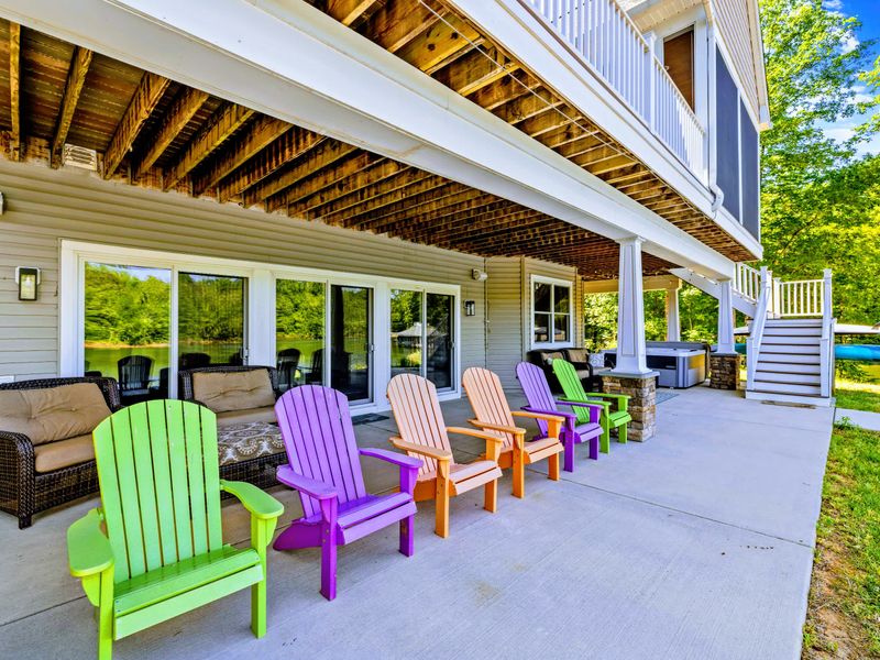 Covered Patio - A rainbow of Adirondack chairs lined up at the rail, each one pointed straight at the water.