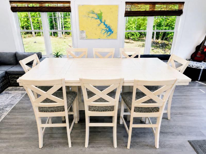 Dining Room - The extendable farmhouse table set against bright windows and a Lake Anna map on the wall.