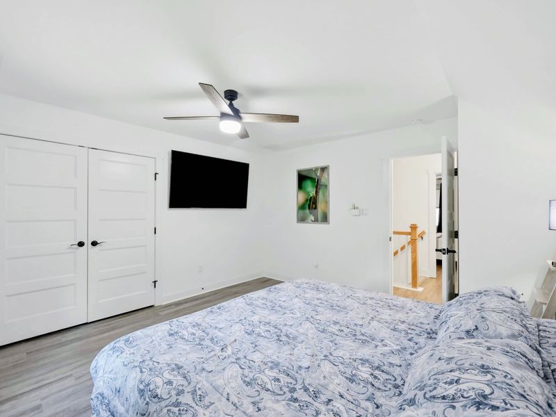 Bedroom - King bed with blue paisley bedding, wildlife photography, and a ceiling fan overhead.