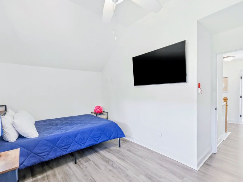 Bedroom - Roomy double-queen setup with a wall-mounted TV and bright natural light.