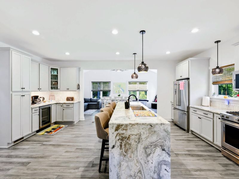 Kitchen - A marble waterfall island with bar seating anchors the bright, open chef's kitchen.