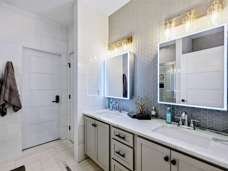 Primary Bath - Double vanity with marble top and LED-backlit mirrors for an unhurried morning.