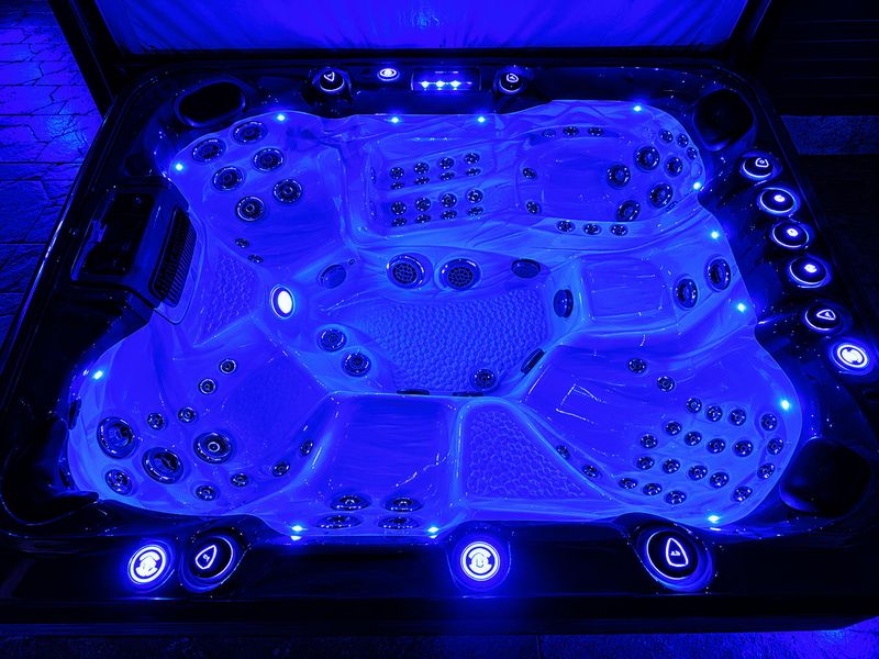 Hot Tub - Overhead view of the premium spa, blue lights illuminating the jets and roomy seating.