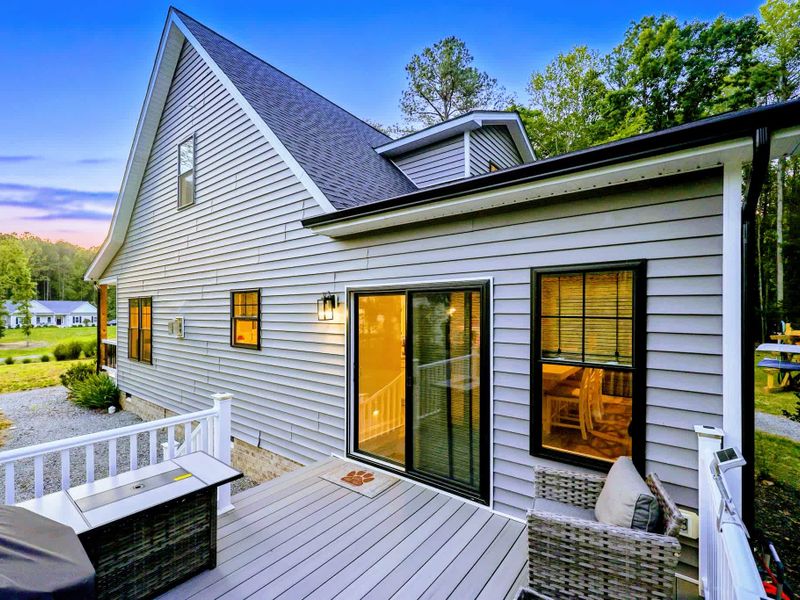 Deck - Side deck and grilling station lit up at dusk, steps from the hot tub and yard.