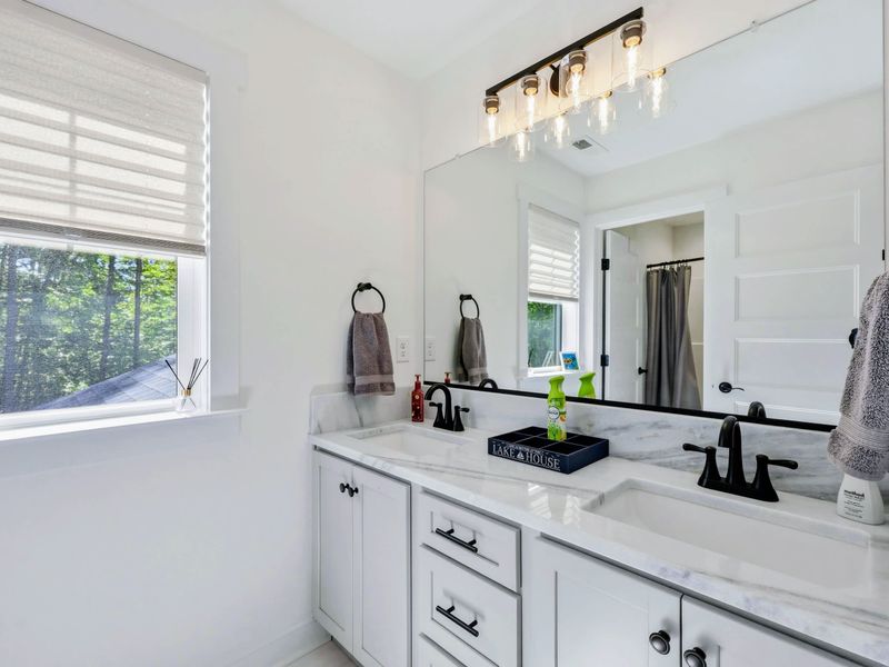 Full Bath - Double vanity with marble counter and a large mirror serving the upper-level bedrooms.