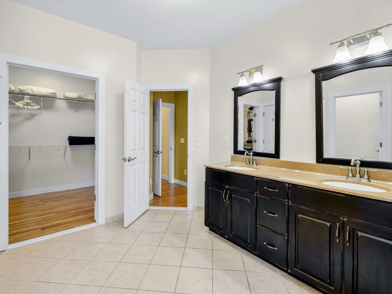 Primary Suite - Double vanity in the ensuite, with a roomy walk-in closet waiting right off the bath.