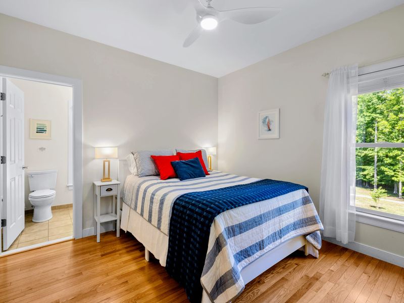 Queen Guest Bdrm - The queen bed sits beside a sunny window, with the ensuite bath right through the door.