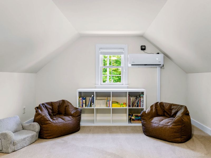 Loft - A cozy reading corner with cubby bookshelves and bean bag chairs beneath the gable window.