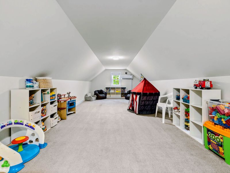 Loft - A long carpeted playroom under the eaves, stocked with a play tent, toy kitchen, Nok-Hockey, and shelves of toys.