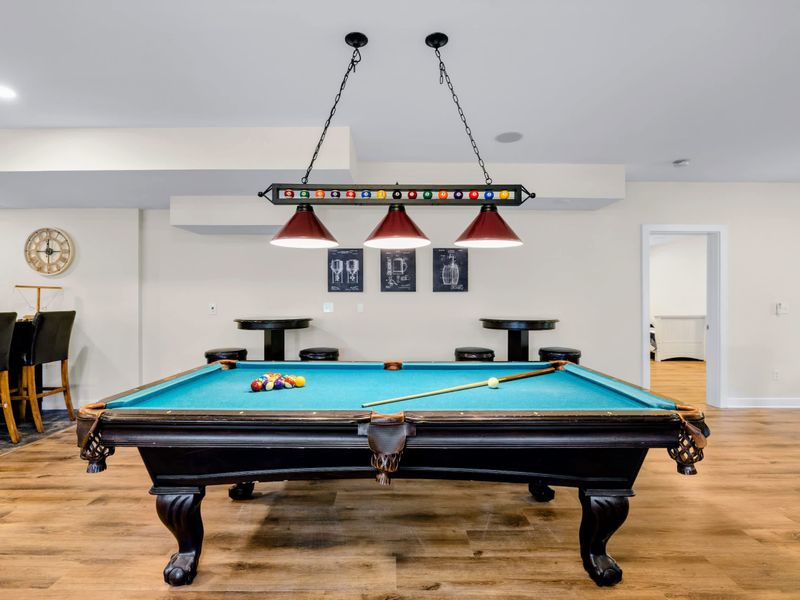 Game Room - The pool table takes center stage under its triple pendant light, balls and cue already out on the felt.