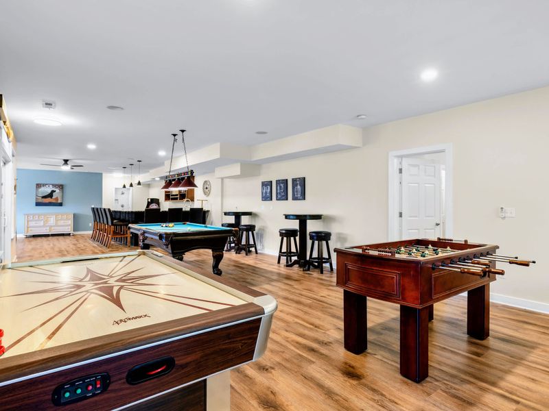 Game Room - Air hockey and foosball up front, the pool table and bar beyond, friendly competition from every angle.