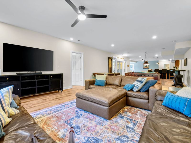 Game Room - The big screen and soundbar face a wraparound sectional, with the pool table and bar just beyond.