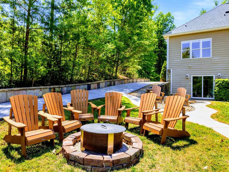Lakefront - Wooden Adirondack chairs ring the fire pit on its concrete base, ready for s'mores once the sun drops.