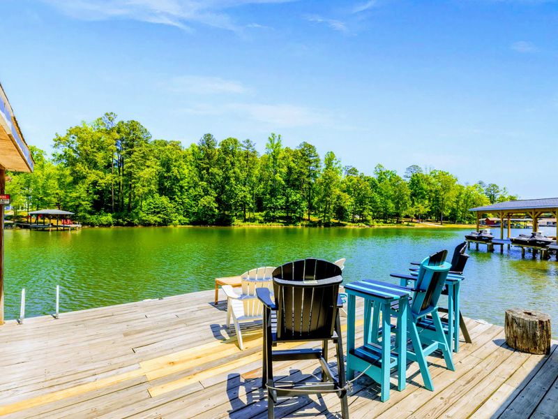 Lakefront - Tall deck chairs line the open dock, front-row seats to calm water and the tree-lined far shore.