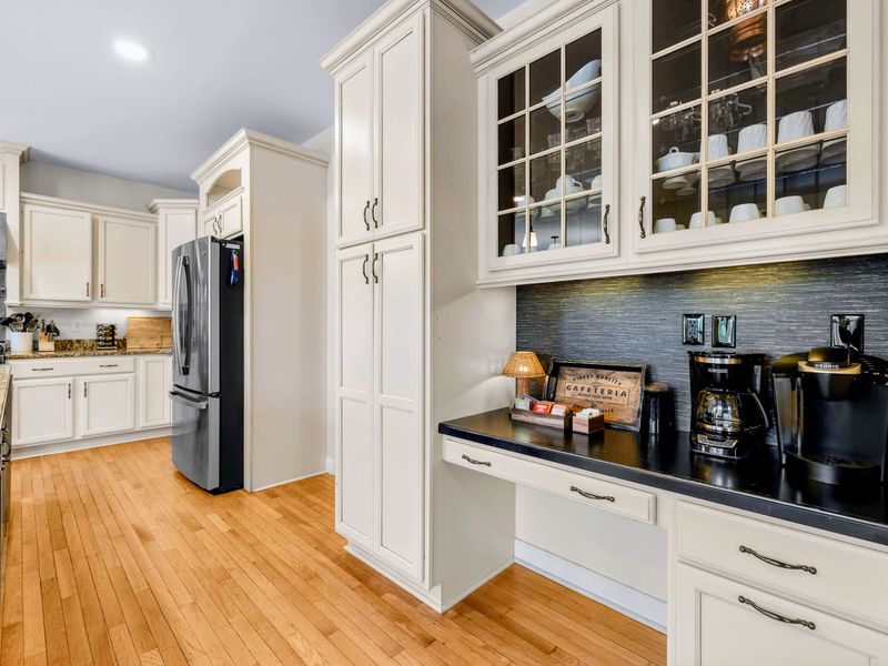 Kitchen - Cream cabinetry runs deep here, with tall pantry storage, a stainless refrigerator, and the coffee station tucked along one wall.