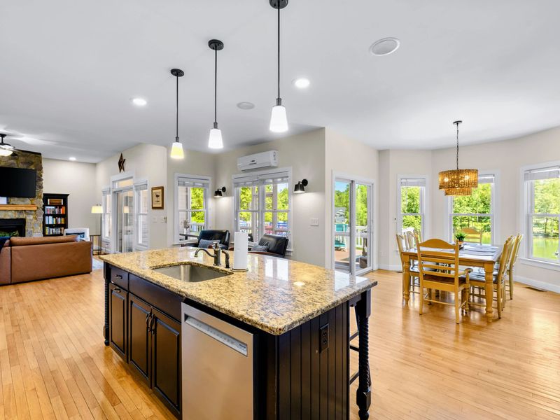 Kitchen - From the island, the stone fireplace, dining table, and lake-facing windows are all in view, one big connected space.