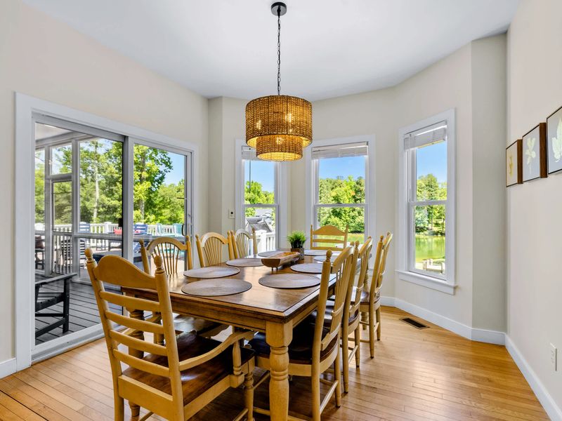 Dining Area 2 - The table sits between deck sliders and sunny windows, offering lake views while everyone lingers after lunch.
