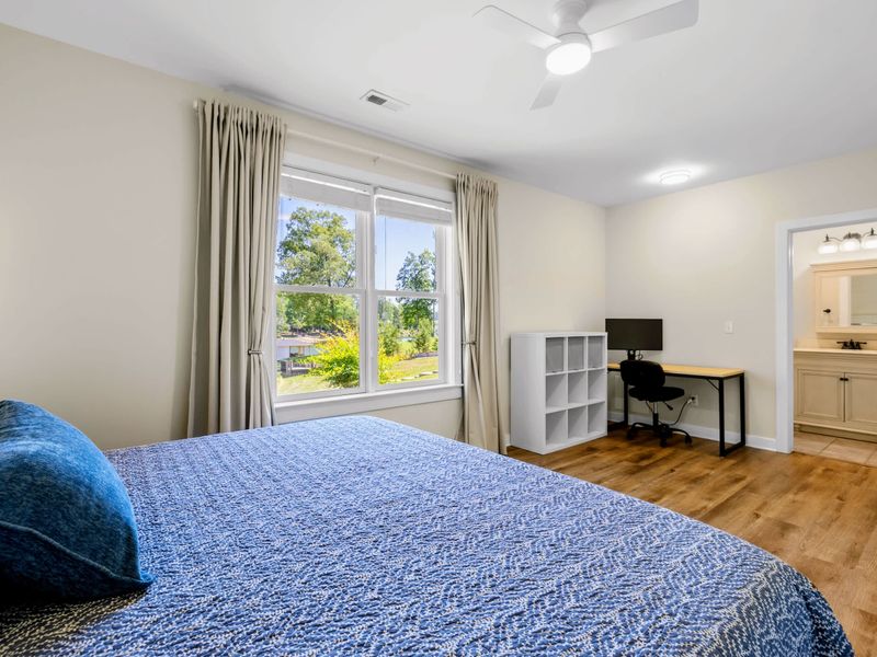 Lower King Guest Suite - From the bed you can spot the desk setup, cube storage, and the ensuite bath through the open door.