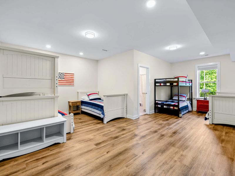 Lower Level Bunk Suite - Room to sleep 7 across beds and bunks, with flag art and plenty of floor space.