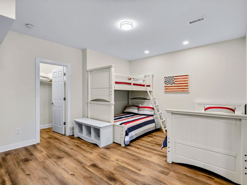 Lower Level Bunk Suite - White twin-over-full bunk with ladder, a neighboring twin bed, and a large closet for everyone's gear.