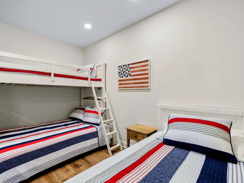 Lower Level Bunk Suite - Red, white, and blue quilts dress the bunk and a twin bed beneath classic flag art.
