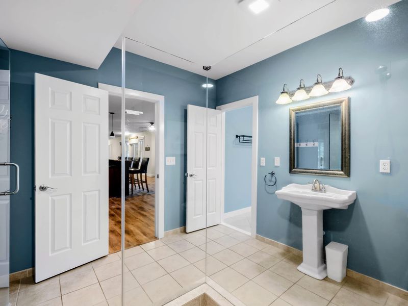 Lower Level Bathroom - Plenty of room to spread out, with a pedestal sink and glass shower near the lower level game room.