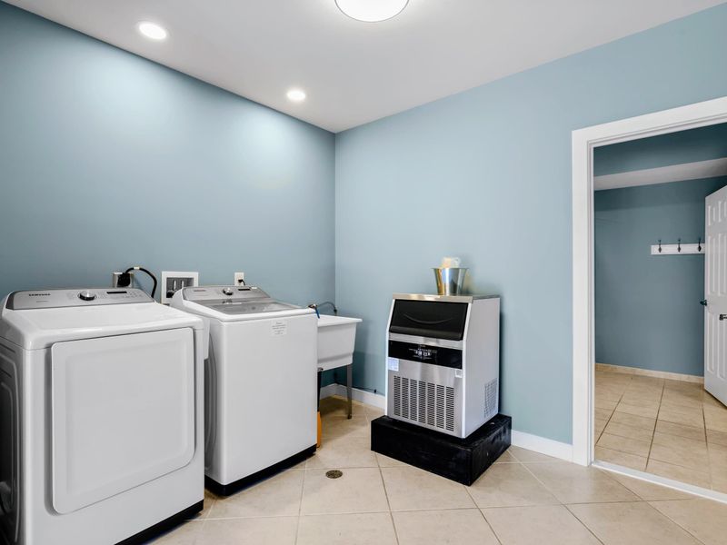 Lower Level Laundry - Washer, dryer, and utility sink, plus an ice maker ready for cooler refills.