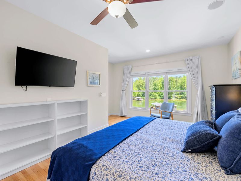 Secondary Suite - Wall-mounted TV above white shelving, and a window framing a gorgeous view of the cove.