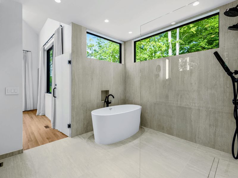 Primary Bath - A clean walk-in shower with a window to the trees.