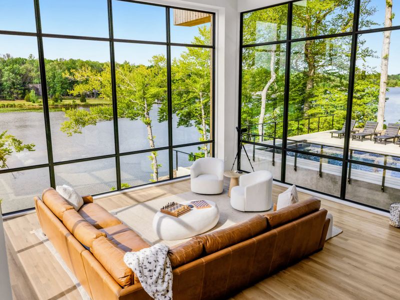 Great Room - The full glass wall opens to pool and lake, seating for the whole group.