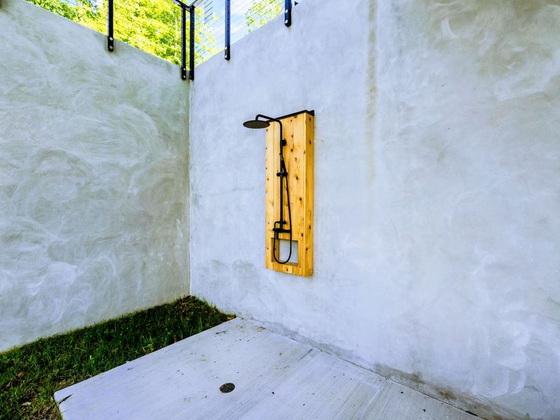 Outdoor Shower - A cedar rain shower in a private concrete enclosure, perfect for rinsing off after the lake or pool.