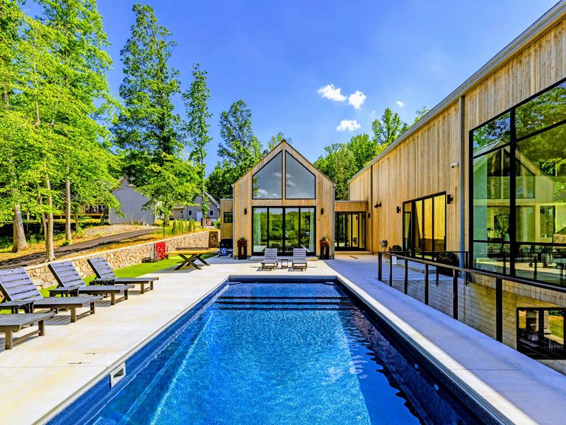 Pool - The pool stretches alongside the home's cedar facade and tall forest.