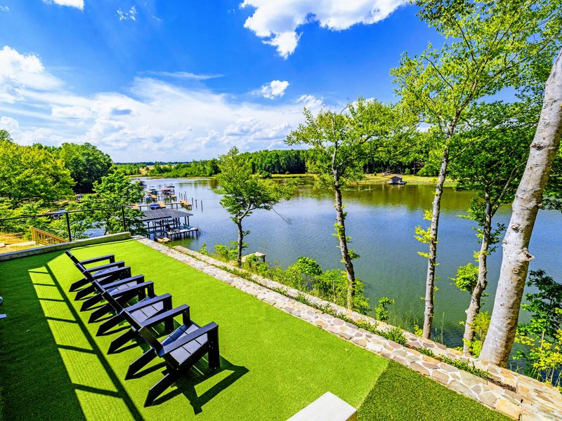 Lakefront Lawn - A row of Adirondack chairs lined up for golden-hour conversation facing the water.