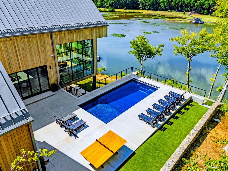 Aerial View - Pool and shoreline framed by forest from overhead.