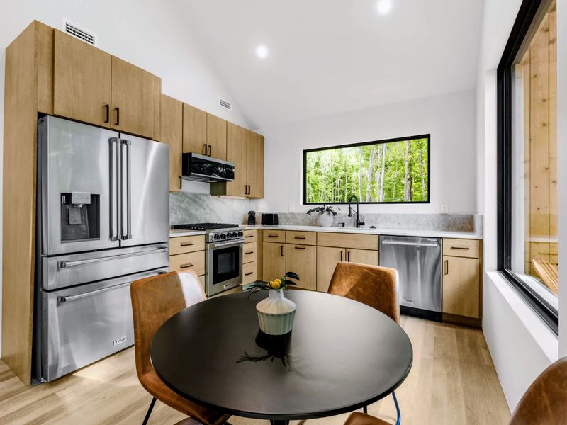 Garage Apartment Kitchen - A full kitchenette with wood cabinets and a round dining table.