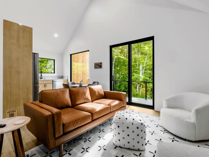 Garage Apartment Living - A leather sofa and glass doors to a private deck.