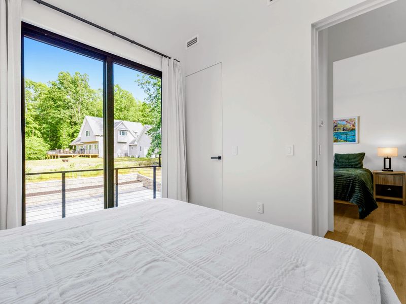 Garage Apartment King - A king bed with glass doors and a view through to the second room.