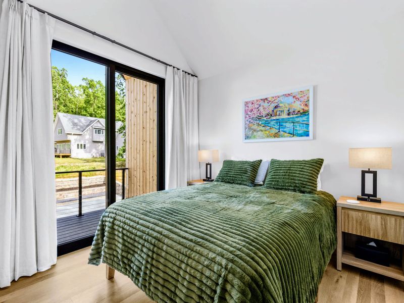 Garage Apartment Queen - The apartment's second bedroom, soft light and a private balcony.