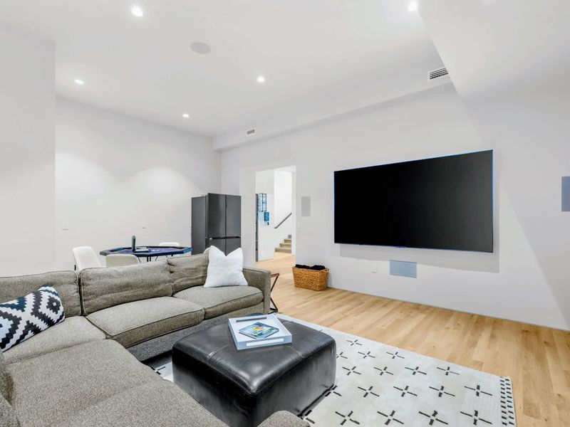 Media Lounge - The mounted TV and sectional anchor the lower-level hangout.