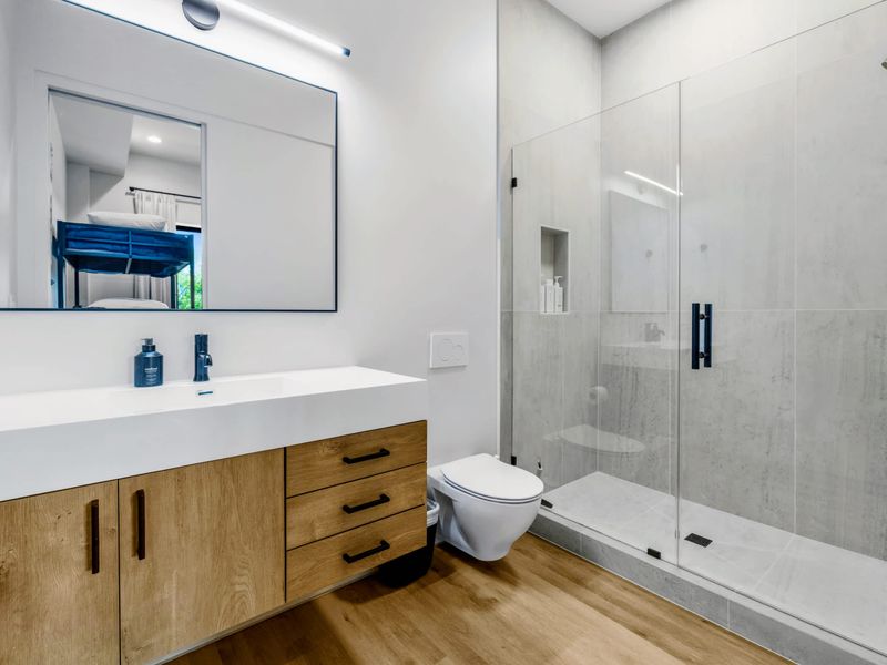 Bunk Room Bath - A double vanity and glass shower serve the kids' wing.