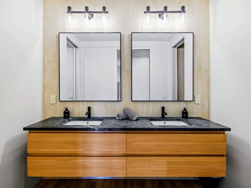 King Bedroom 5 - The ensuite double vanity with clean stone and matte black fixtures.