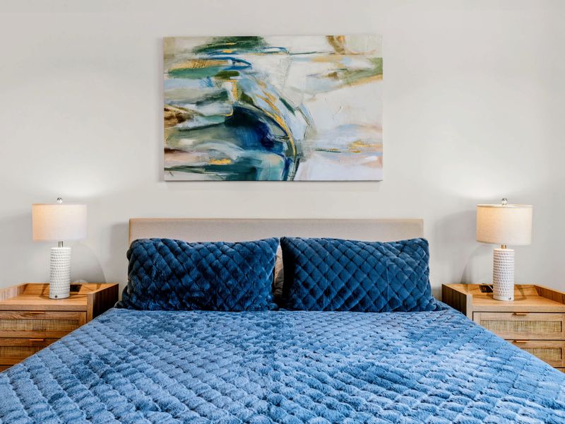 King Bedroom 5 - A king bed in deep blue with lake-inspired art above the headboard.