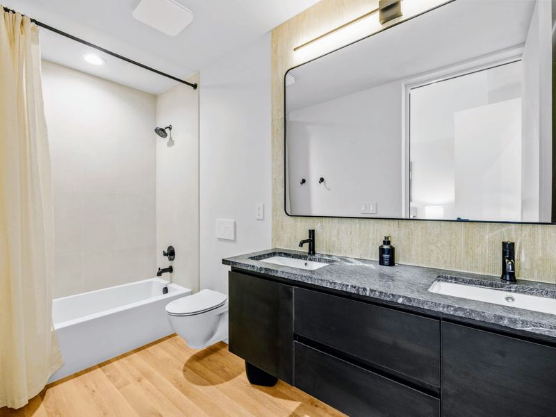 Upstairs King Suite - The ensuite pairs a tub-and-shower with a double vanity.
