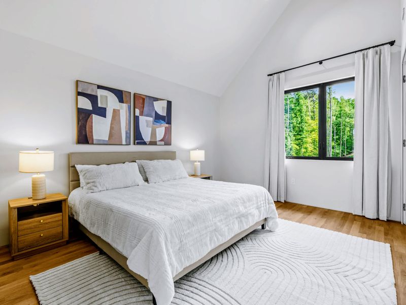 Upstairs King Suite - King bed with a window to the trees and a calm, modern feel.