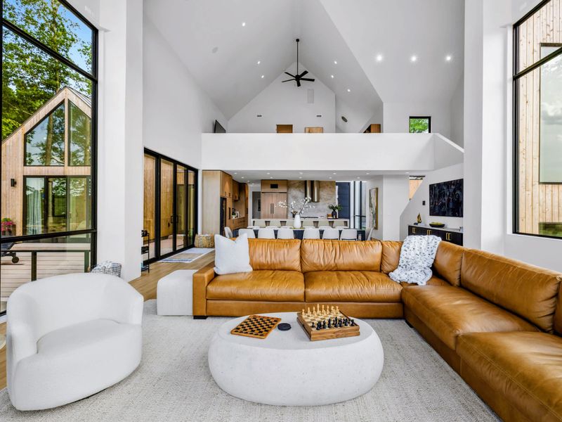 Great Room - Floor-to-ceiling glass pulls the forest and water into the main living space.