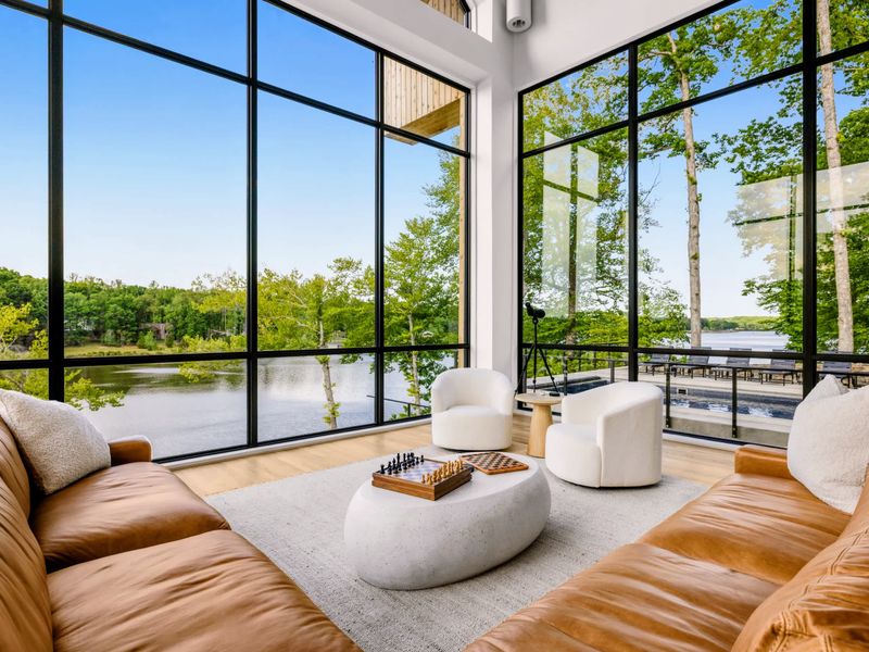 Great Room - White lounge chairs and a deep sectional gather around the view.