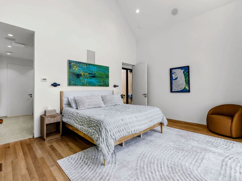 Primary Suite - King bed, original art, and a quiet sitting corner to start the day slow.