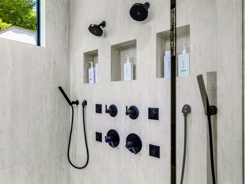 Primary Bath - A walk-in shower with body sprays and brass fixtures, more spa than bathroom.