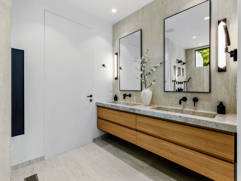 Primary Bath - A long double vanity with twin mirrors and warm wood below.